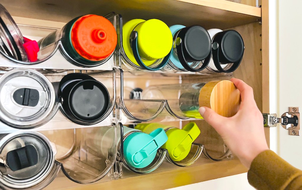 hand pulling water bottle from clear organizers