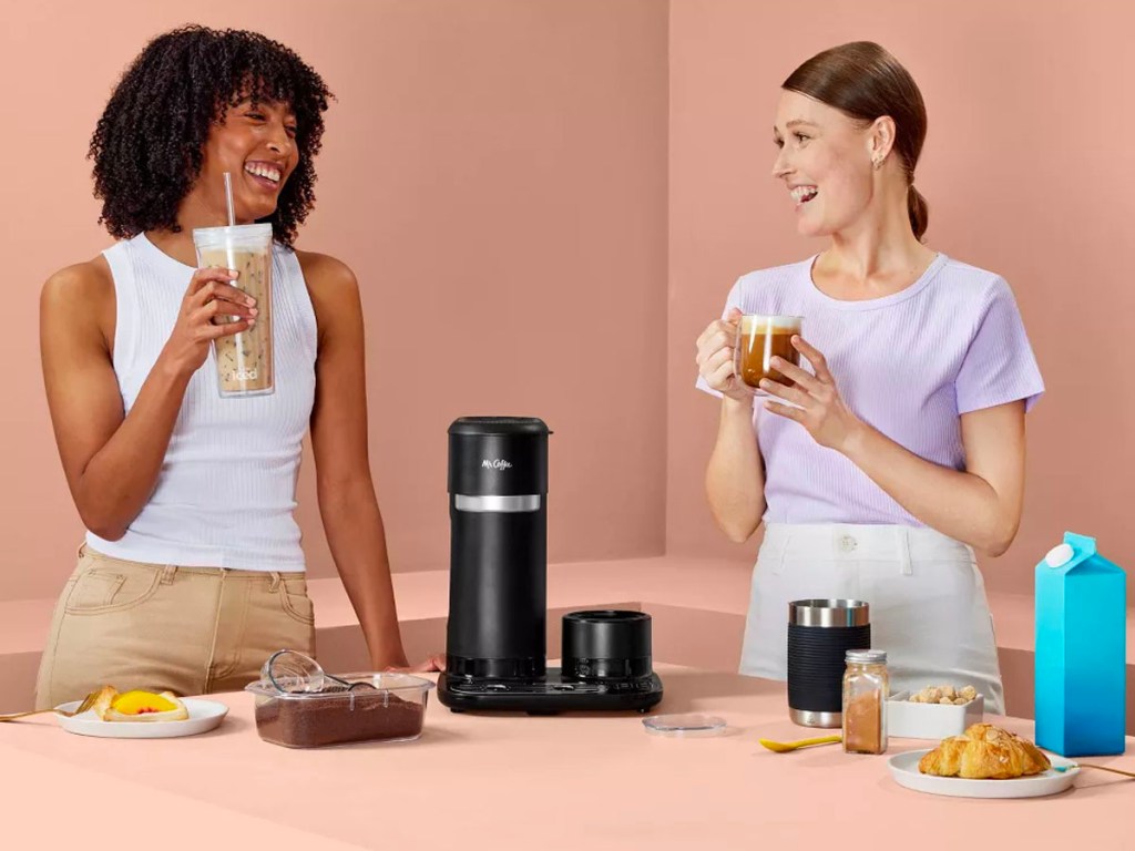 two women making and drinking drinks using the mr coffee 4-in-1 maker