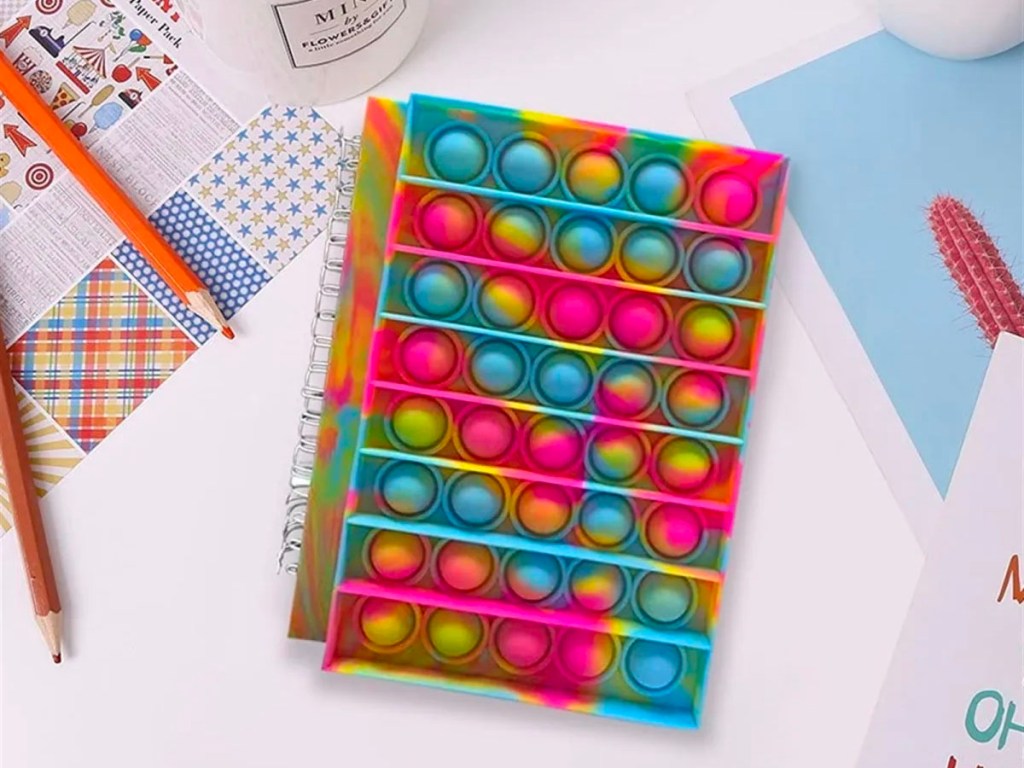 push pop notebook on table with pens and other office supplies