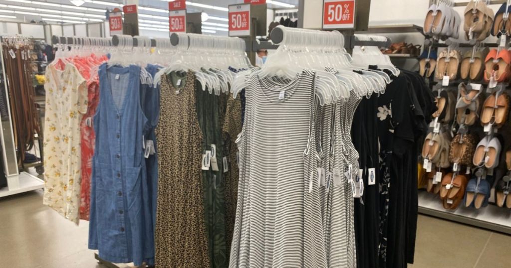 racks of summer dresses at old navy with sale signs for 50% off