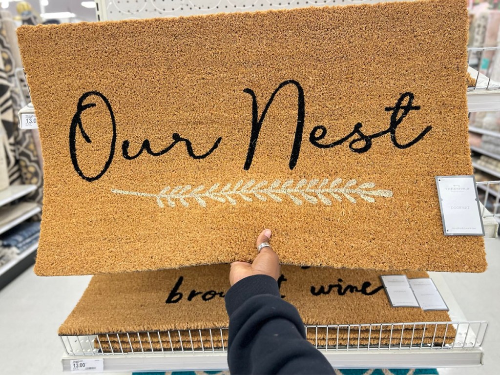 hand holding our nest doormat