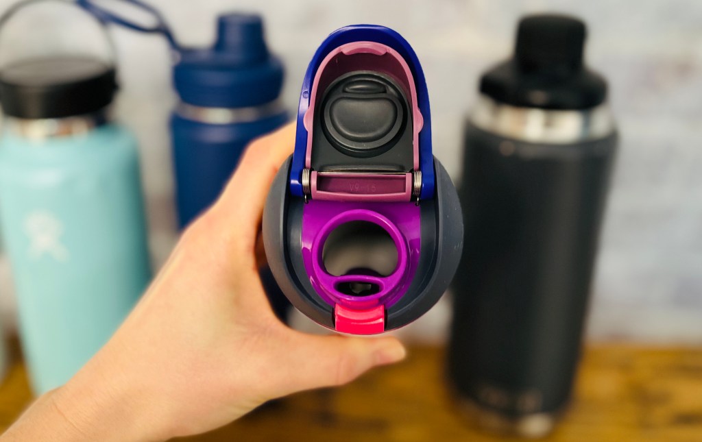 hand holding a purple water bottle showing the inside of drinking cap