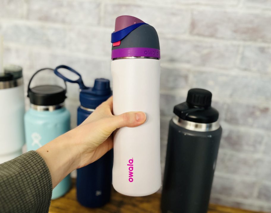 hand holding an owala freesip purple water bottle