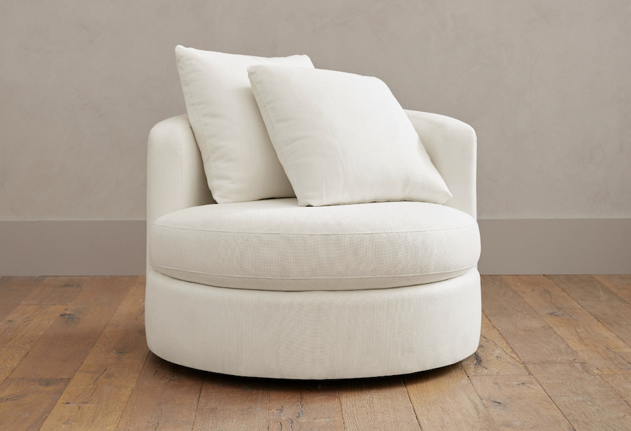 stock photo of white swivel armchair on wood floor
