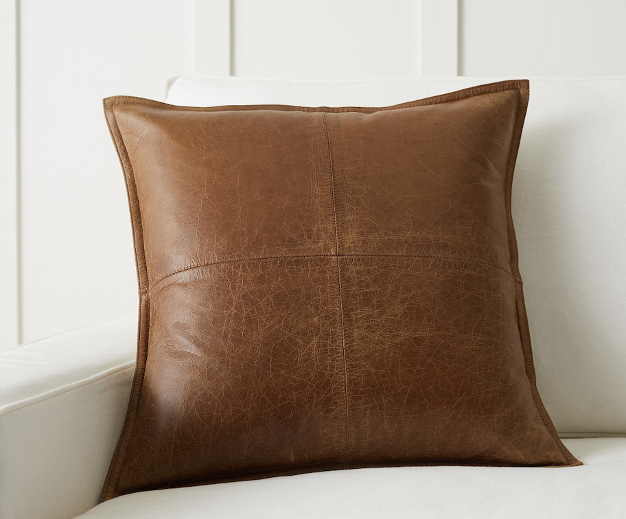 brown leather pillow on white chair