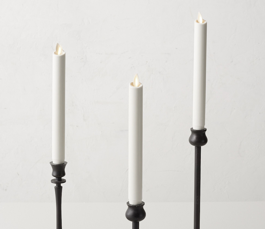 white flameless candles in black candle stick holders