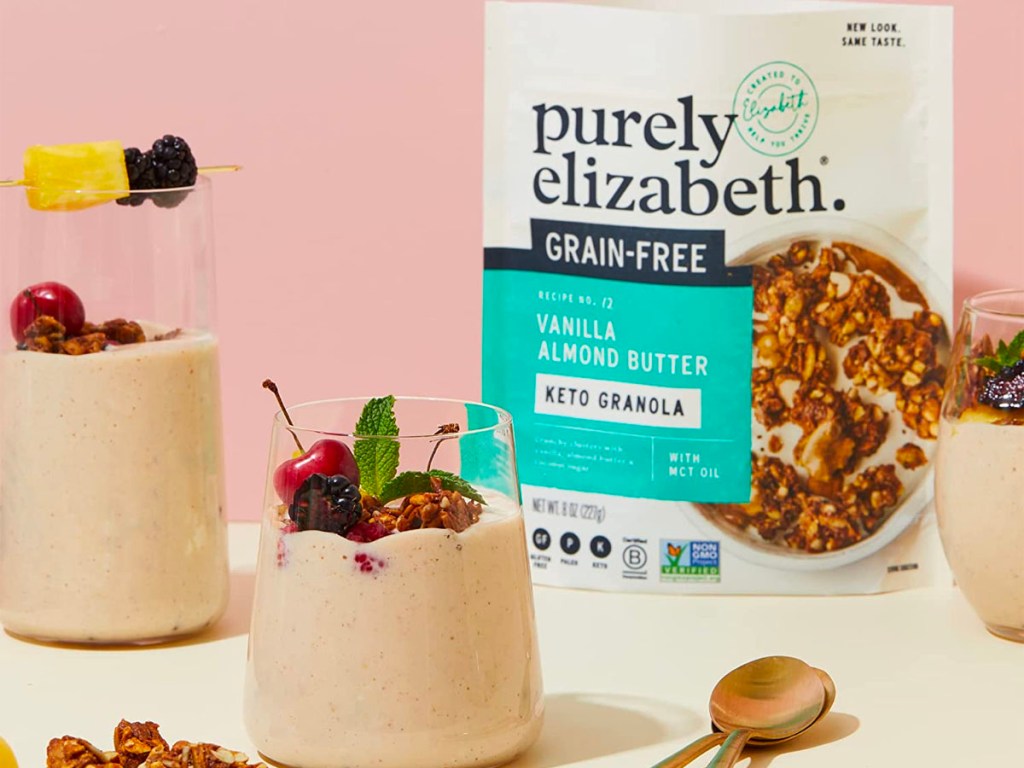 purely elizabeth almond butter granola bag on counter with two granola smoothies with fruit on top