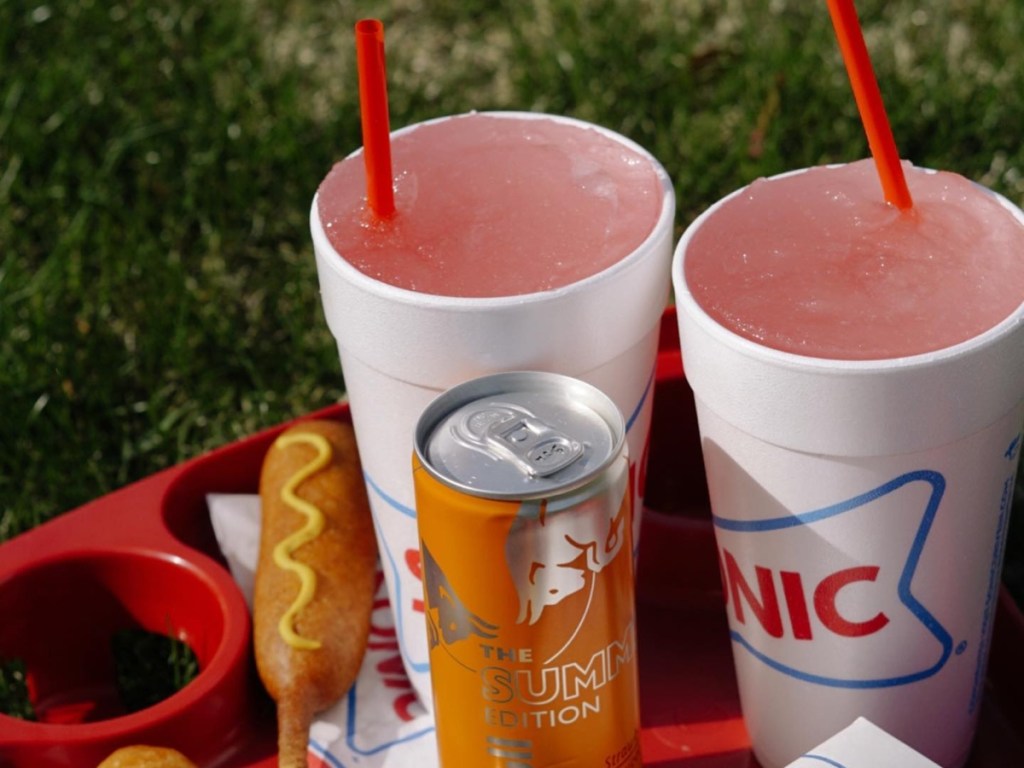 two pink slushes, a can of Red Bull Summer Edition, and a corn dog from Sonic