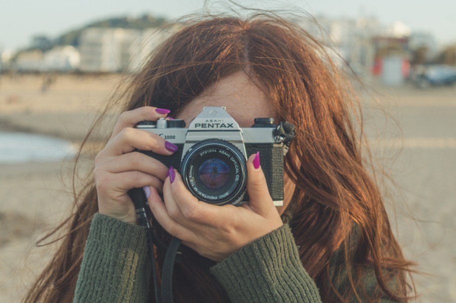 A redhead with a camera, perhaps studyihng thanks to odd scholarships for redheads