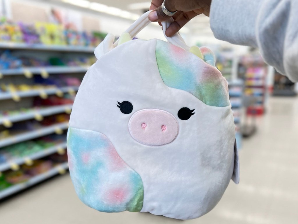 hand holding pig squishmallow easter basket