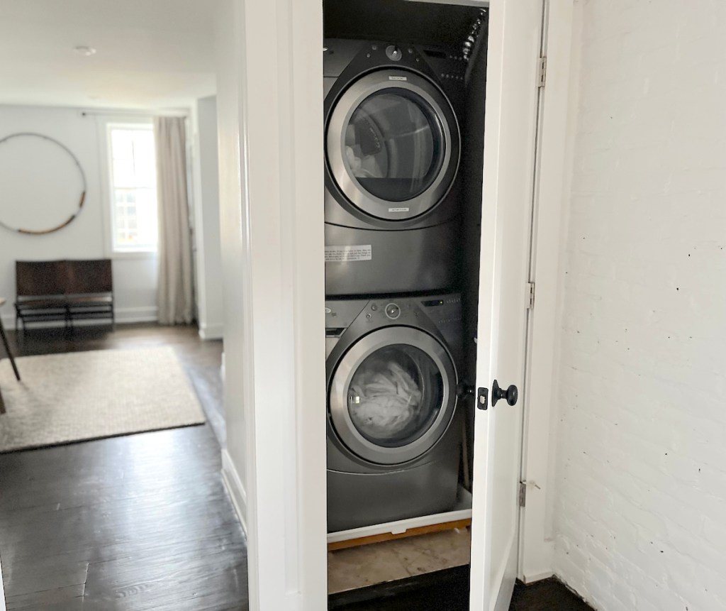 stackable laundry appliances in closet in hallway of home