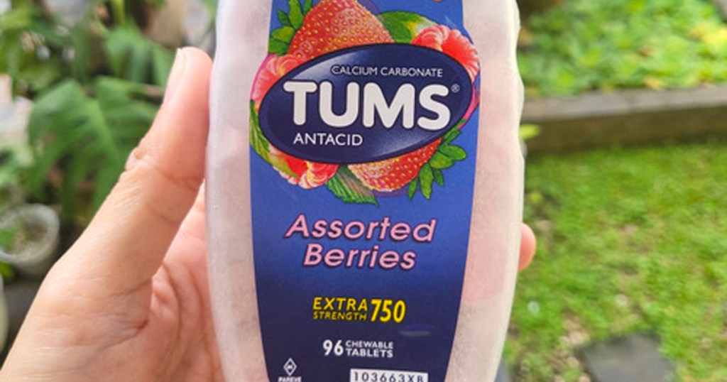 hand holding bottle of tums assorted berries 