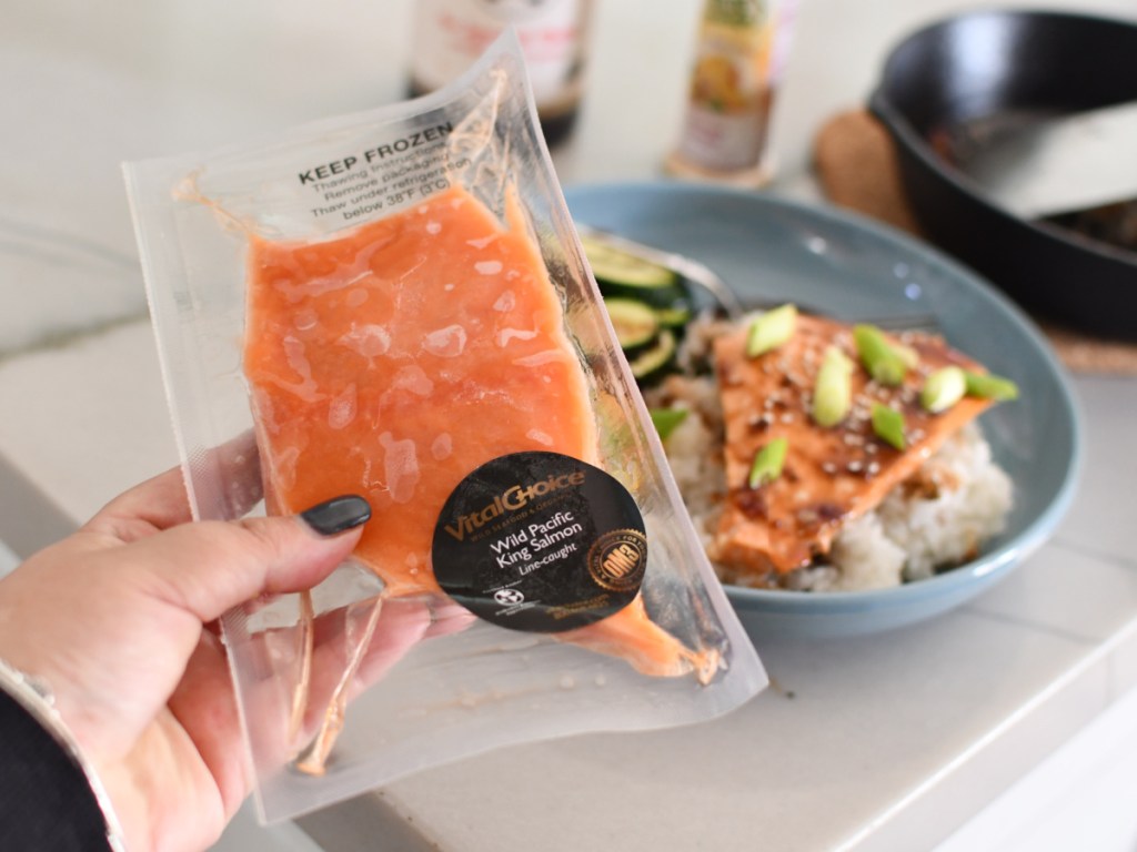 frozen salmon next to cooked meal