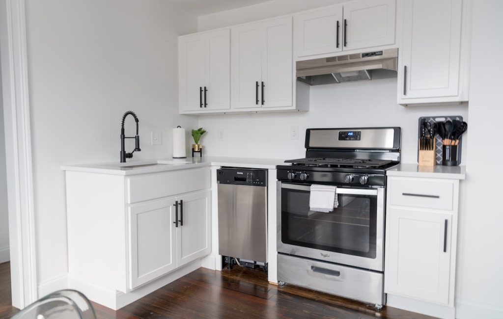 white kitchen with stainless steel appliances home renovation tips