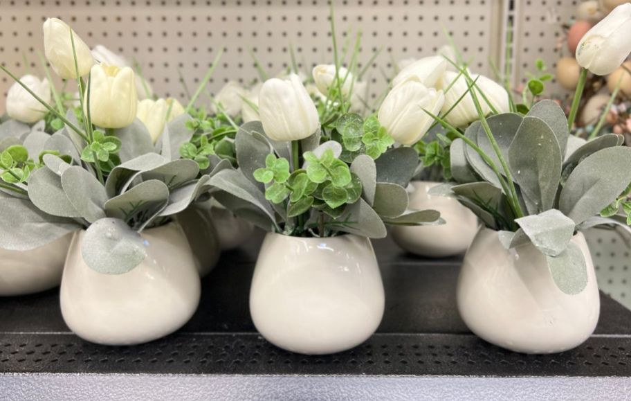 3 white tulip planters in a row on a store shelf