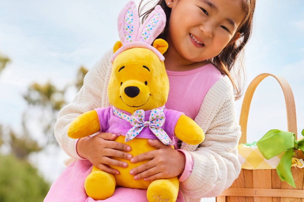 girl holding winnie the pooh plush with easter basket