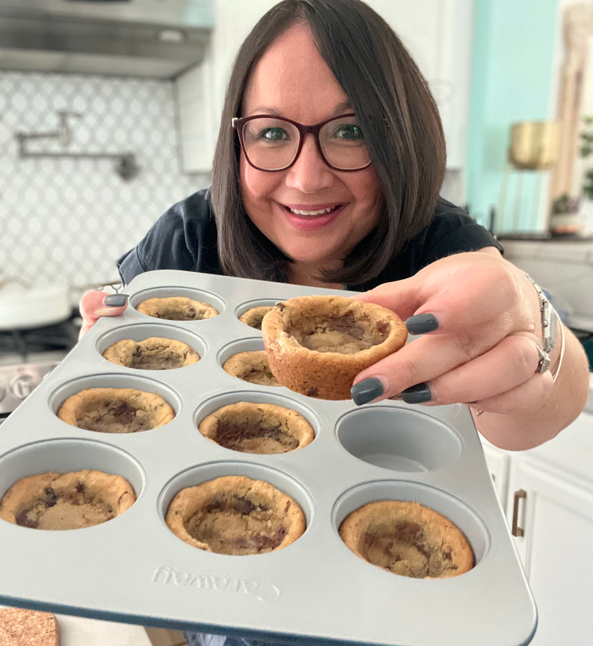 Woman holding chocolate chip cookie bowls. 