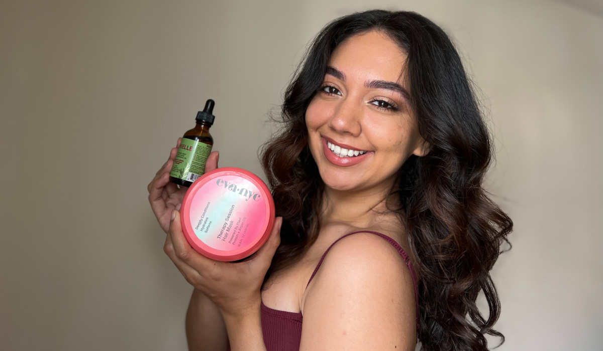 woman holding eva nyc therapy session hair mask and mielle hair oil