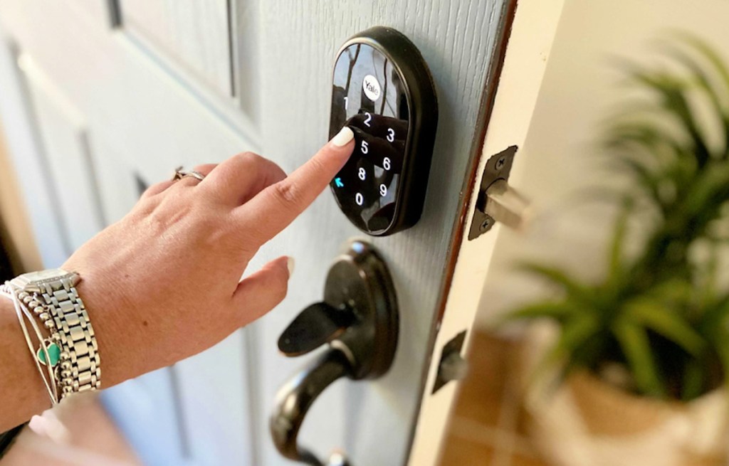 finger pushing numbers on front door lock for airbnb essentials