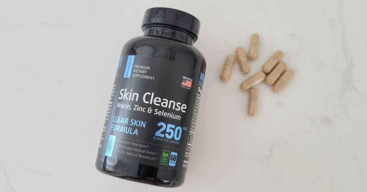 Raw Science Perfect Skin bottle and capsules laying on counter
