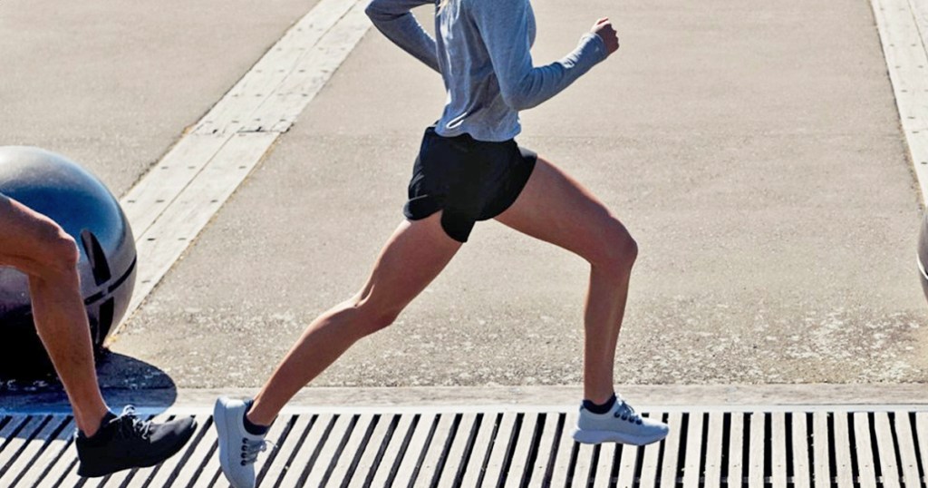 woman running in black shorts and grey long sleeve tee