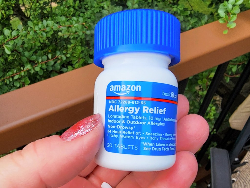 hand holding a bottle of Amazon Basic Care Allergy Relief