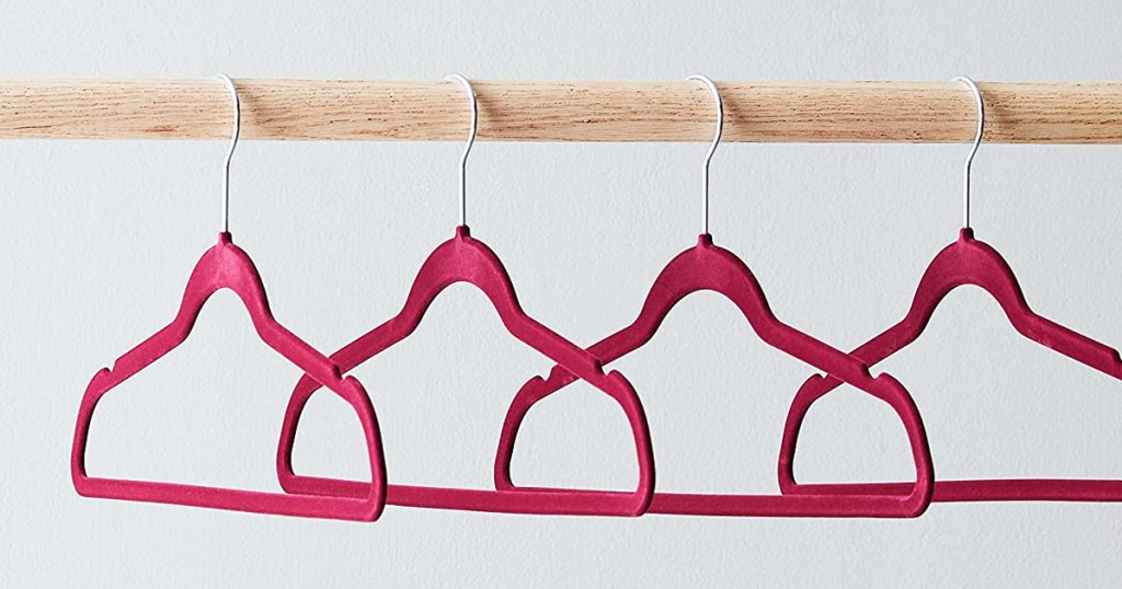 red velvet hangers hanging on wood rod