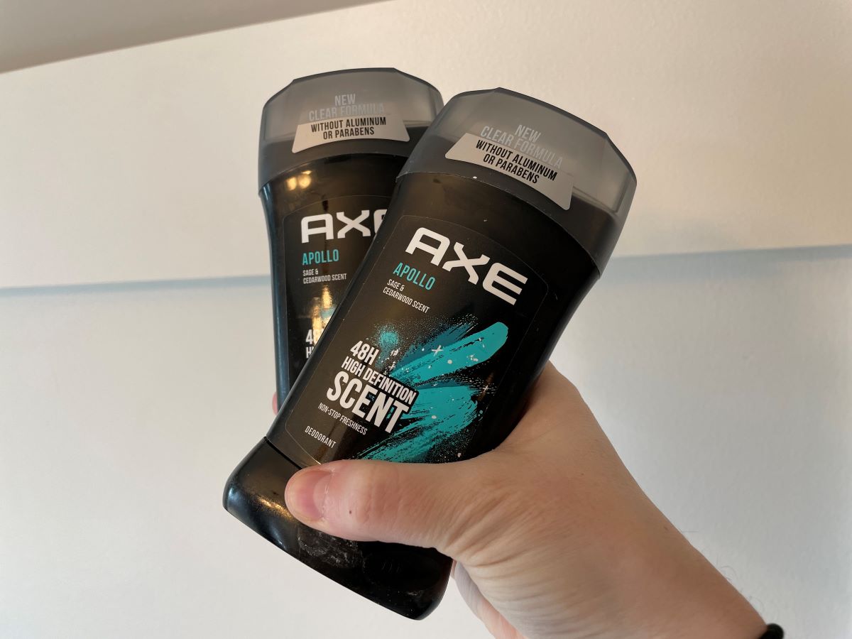Hand holding two Axe deodorants