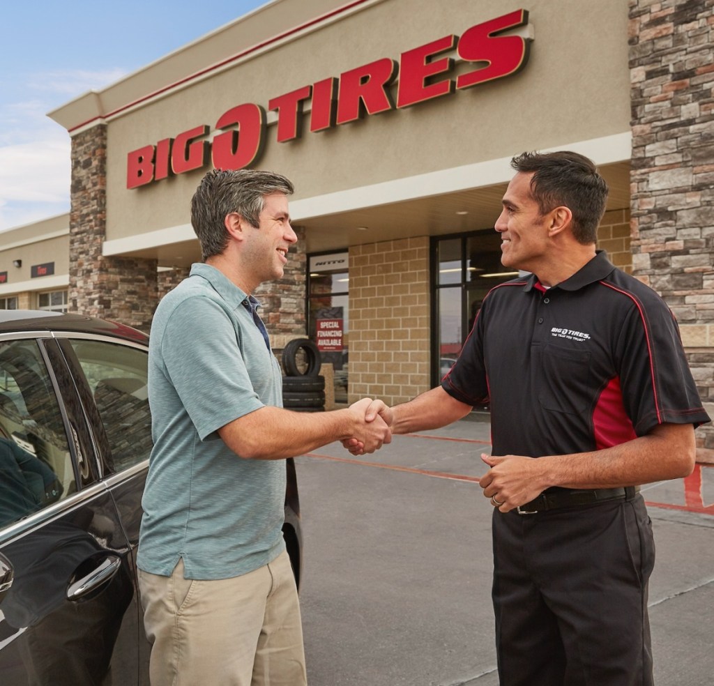 Big O Tires representative shaking hands with a customer