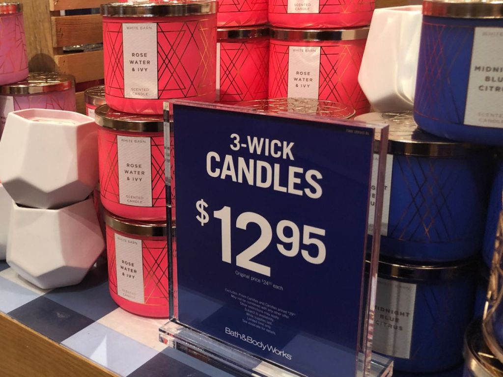 Bath & Body Works 3-wick candles with sign in front that says they are $12.95