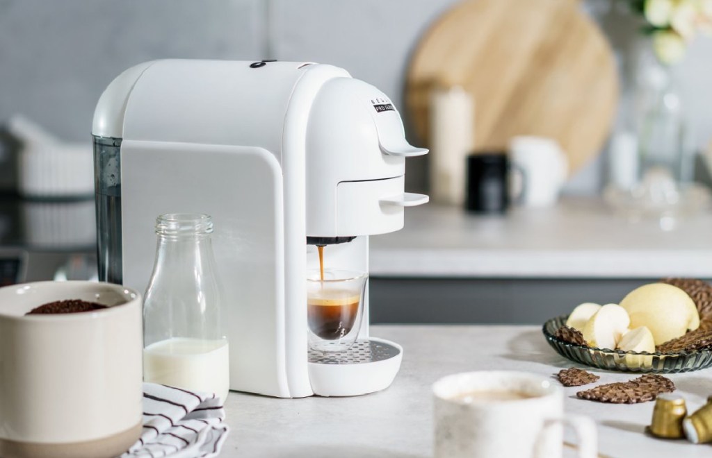 ماكينة صنع الإسبريسو بيلا مع القهوة التي تصنعها مع القهوة من حولها
