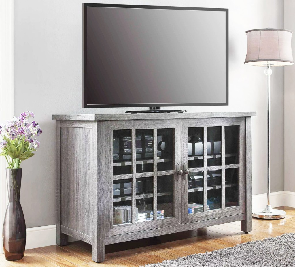 grey tv stand with plant and lamp on either side
