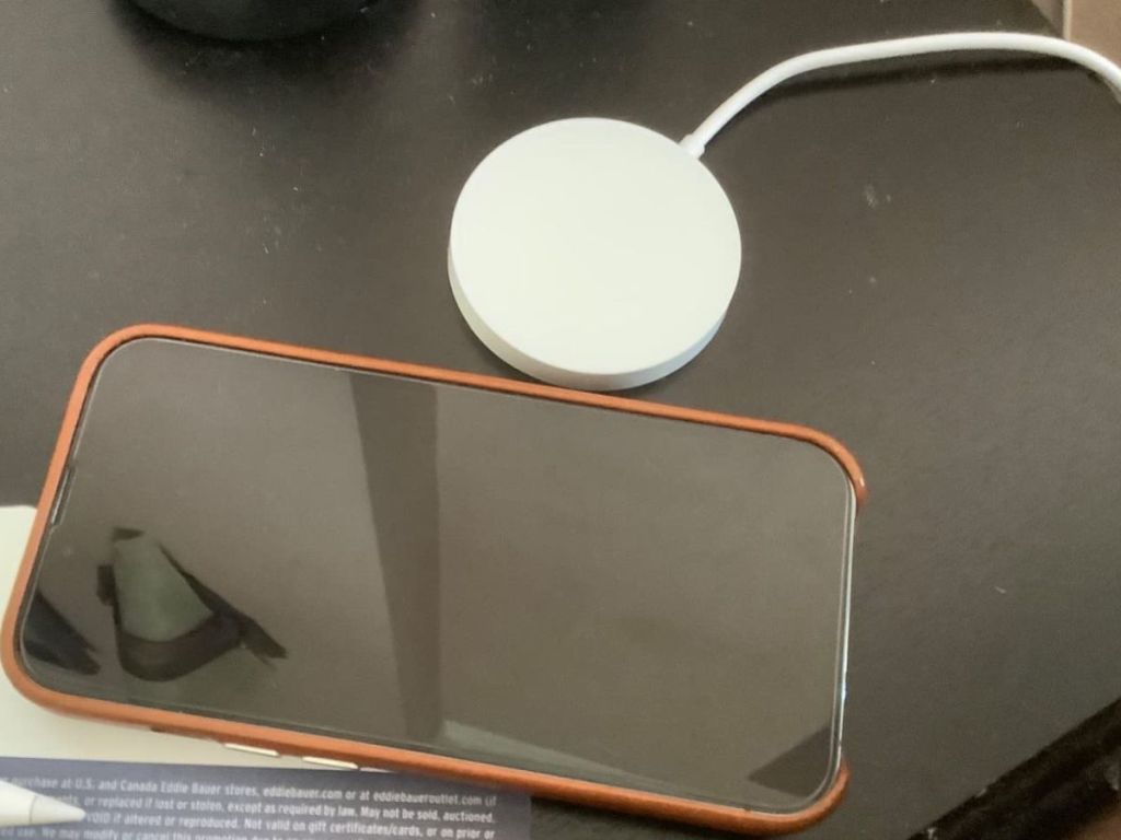 Wireless charger set next to an iphone on a table