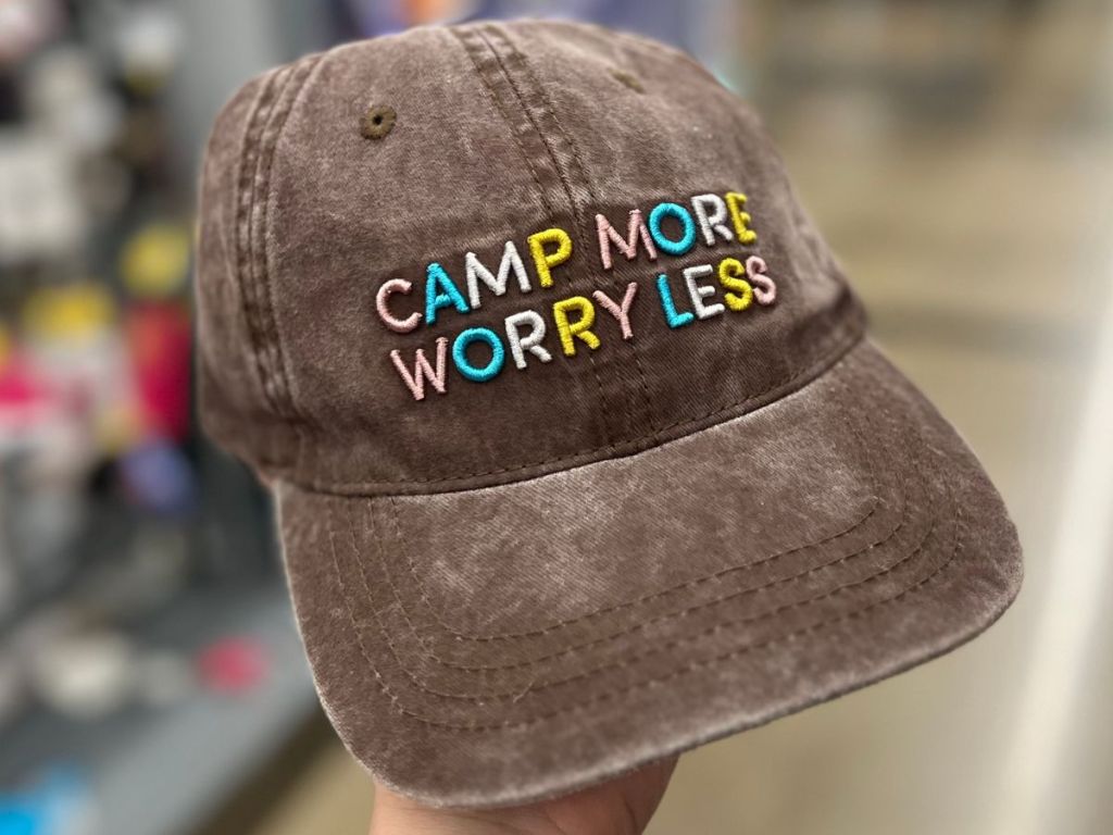 A brown baseball cap with the letters Camp More Worry Less