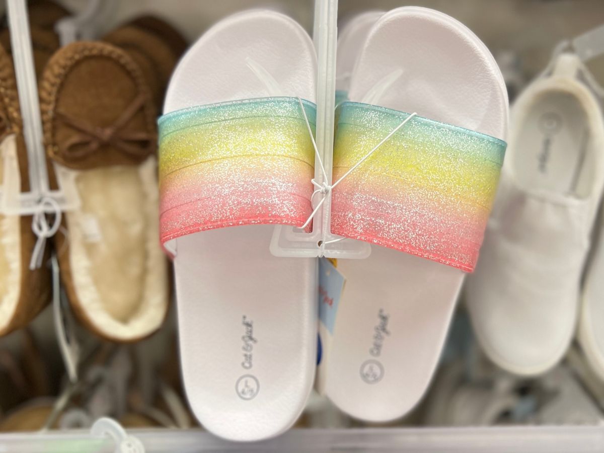 A pair of Cat & Jack summer slides in white with a rainbiow footband