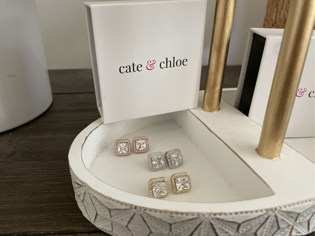 3 pairs of sparkly square earrings in jewelry holder with cate & chloe box nearby