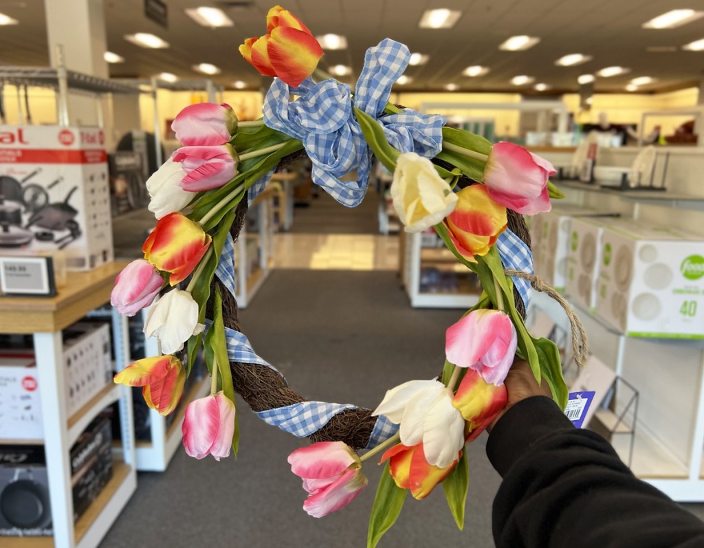 holding up spring tulip wreath in store