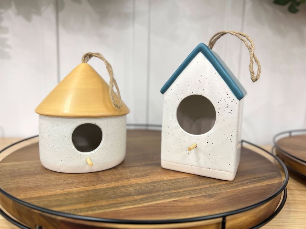 Two ceramic birdhouses sitting on a tray