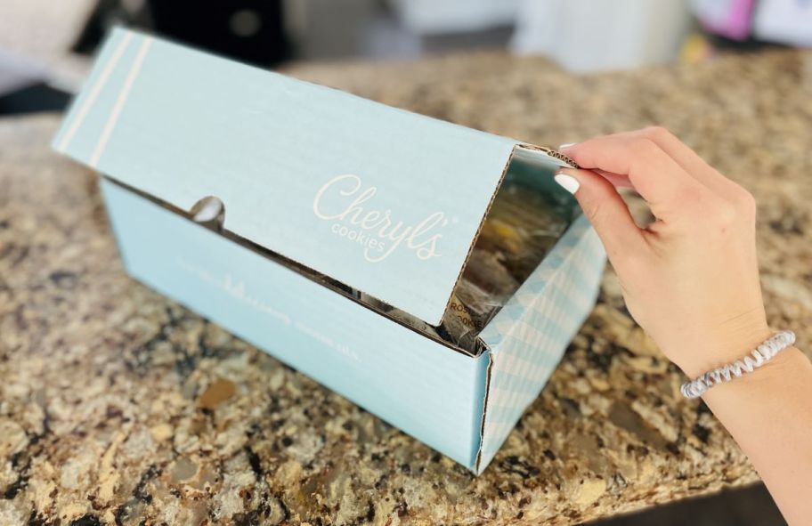 Hand opening a Cheryl's Cookies Box