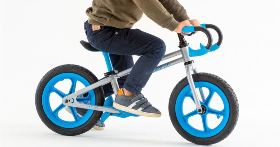 a little boy riding on a balance bike