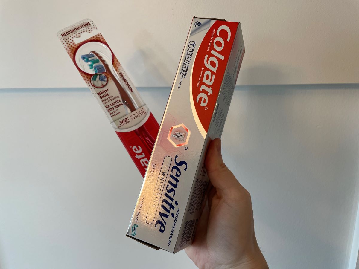 Hand holding a Colgate Toothbrush and Toothpaste