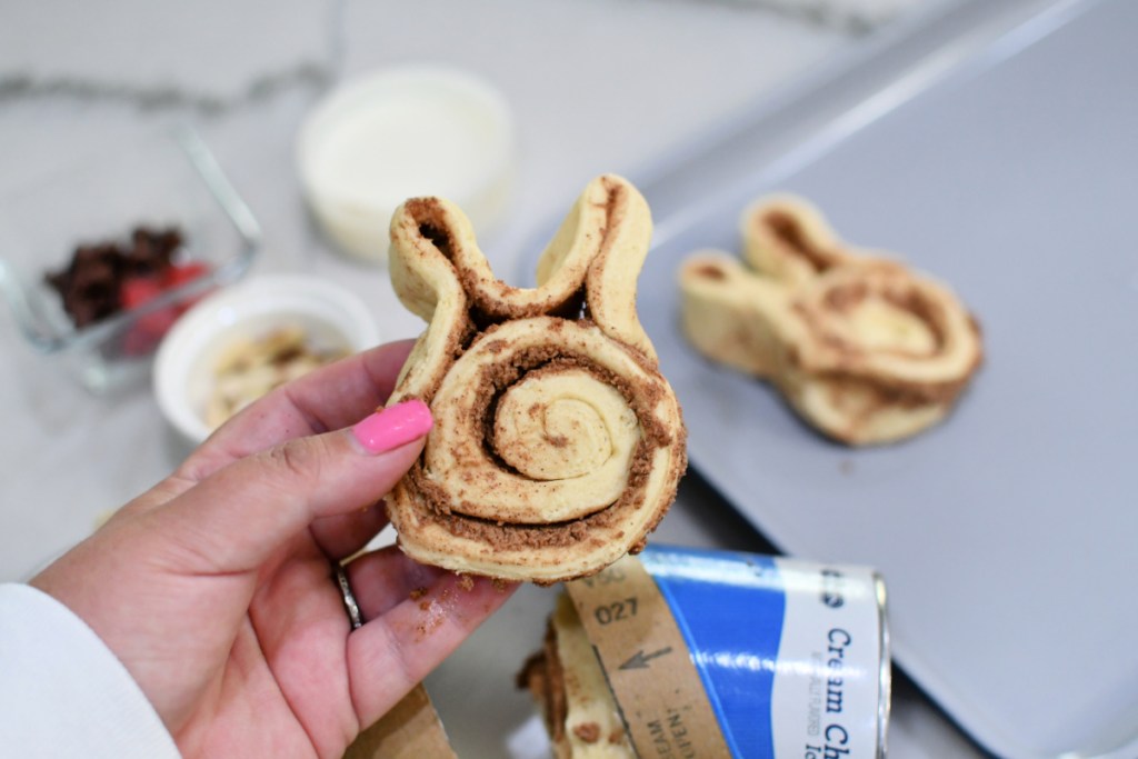 holding a cinnamon roll shaped like a bunny 