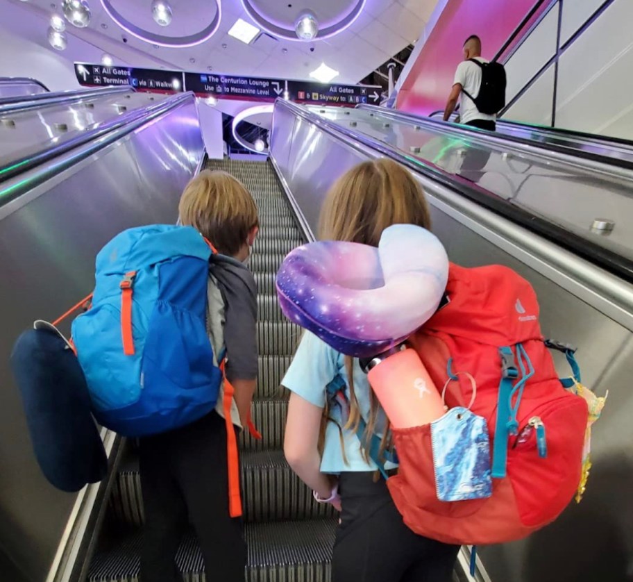two kids on escalator wearing deuter travel backpacks