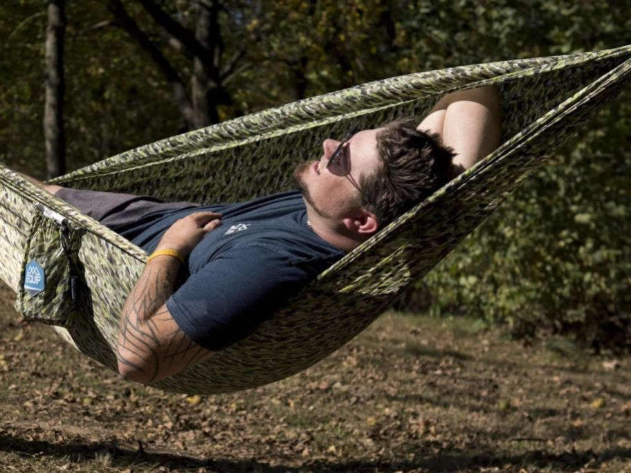 A man in a green tree hammock