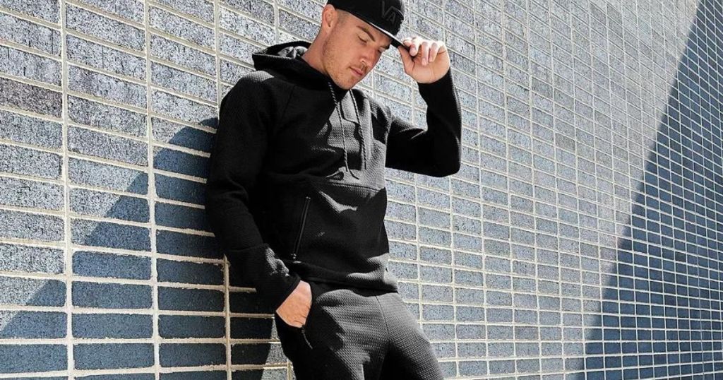 Man leaning against a wall wearing FLX clothing from Kohl's