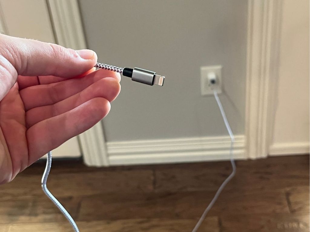 hand holding an extra long charger in wall