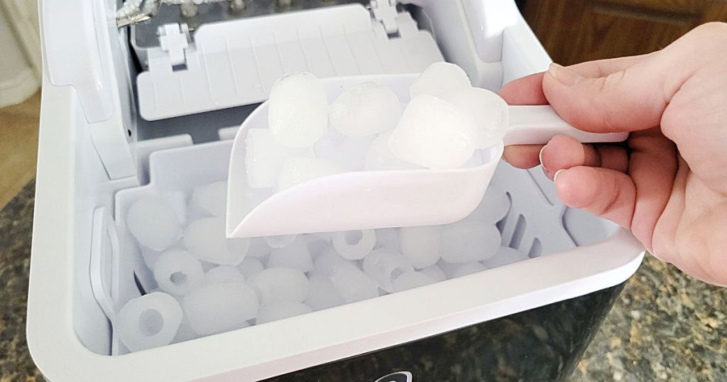 person taking scoop of ice from Portable Countertop Ice Maker