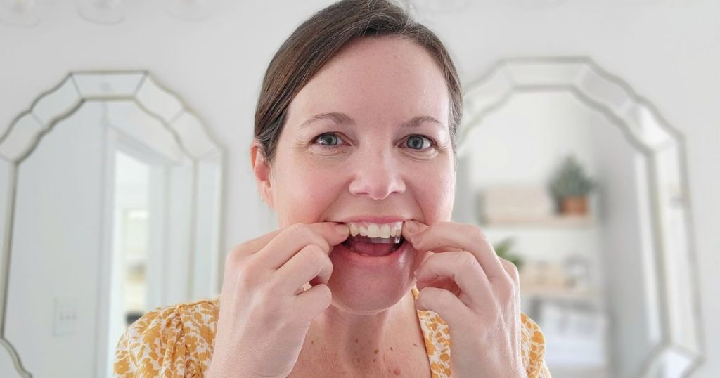 woman putting on teeth whitening strip