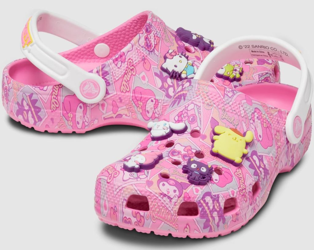 Pair of pink Crocs with Hello Kitty designs all over and Hello Kitty Jibbitz charms