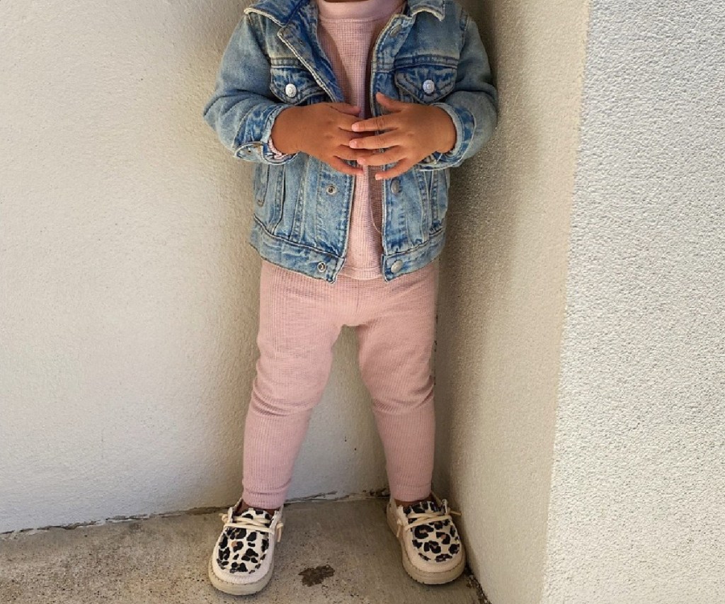 little girl in mathing pink outfit, jean jacket and Hey Dudes kids shoes